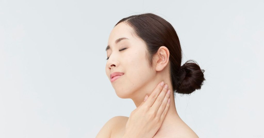 Woman touching her neck after her facelift (model)
