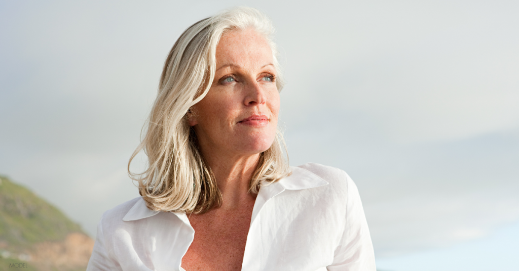 Older, beautiful woman contemplates finding the best facelift plastic surgeon.